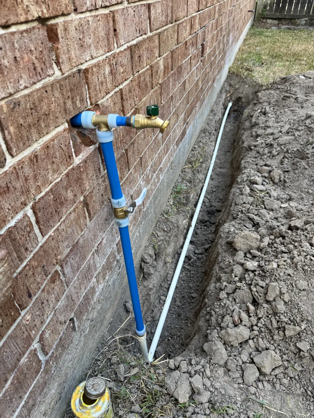 New outdoor hose bib on a brick wall with fresh water line